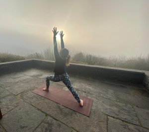 mother doing yoga outdoors early morning